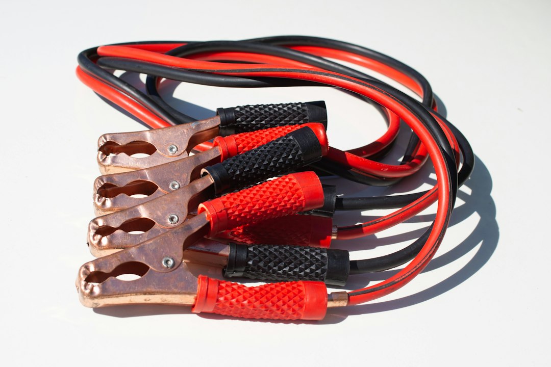 Jumper cable clamps ready to connect to a car battery