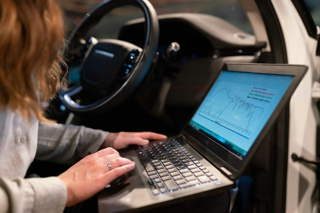 Technician reviewing diagnostic data inside a car